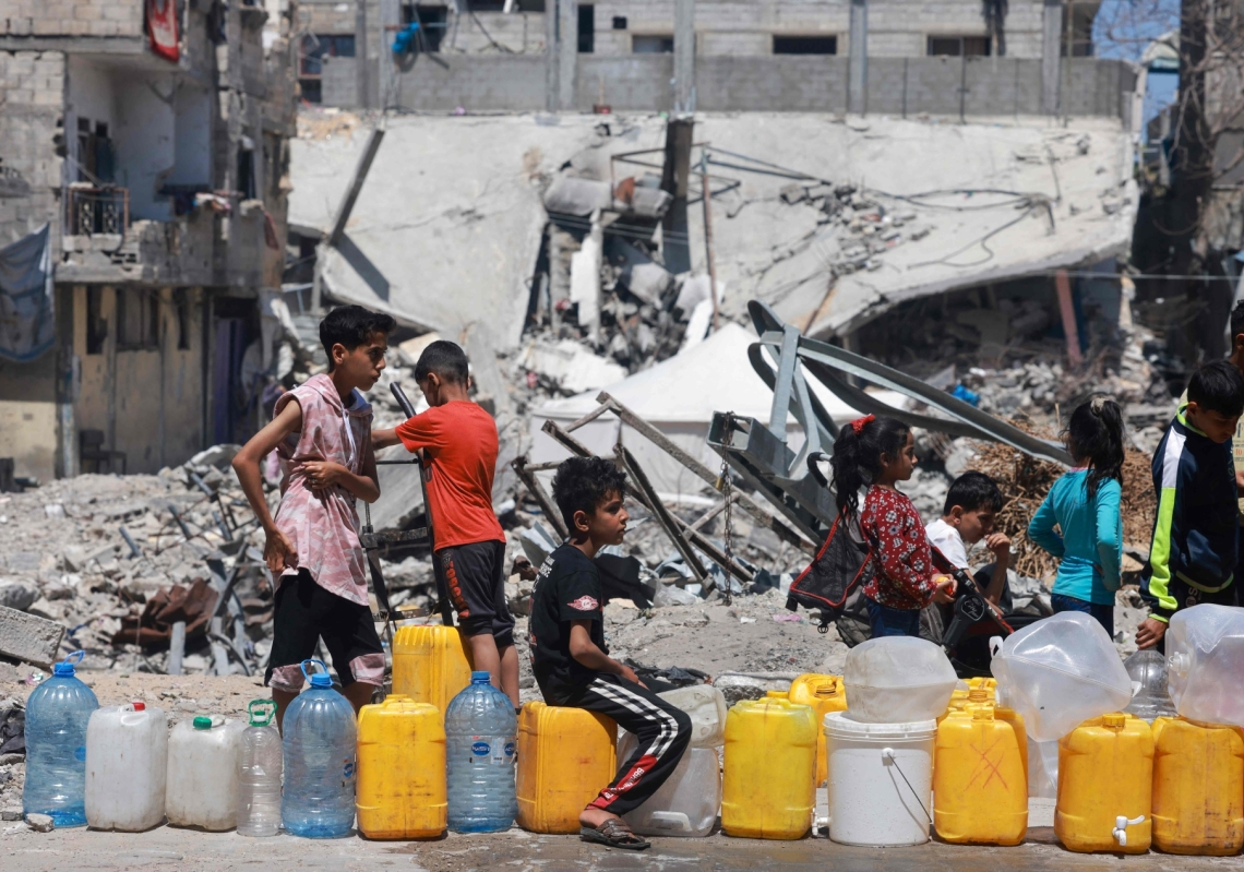 Displaced Palestinians line up to fill their containers with water in Rafah, on the southern Gaza Strip on April 19, 2024.